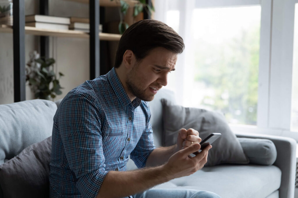 Male landlord looks worried as he receives a text from a tenant about emergency property maintenance